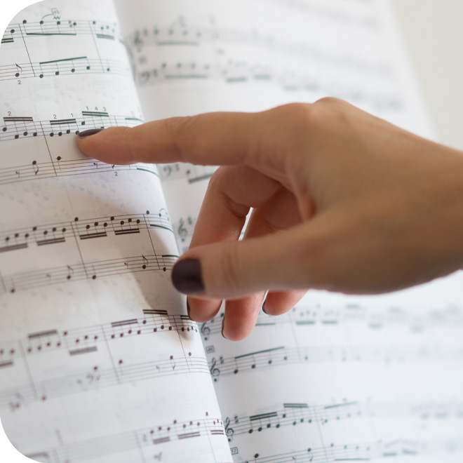 finger pointing to music notes